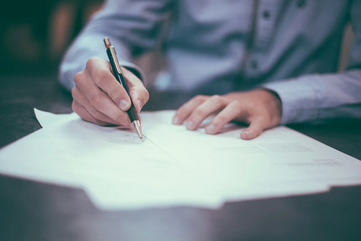 Business owner signing company registration documents with J&P Ventures experts